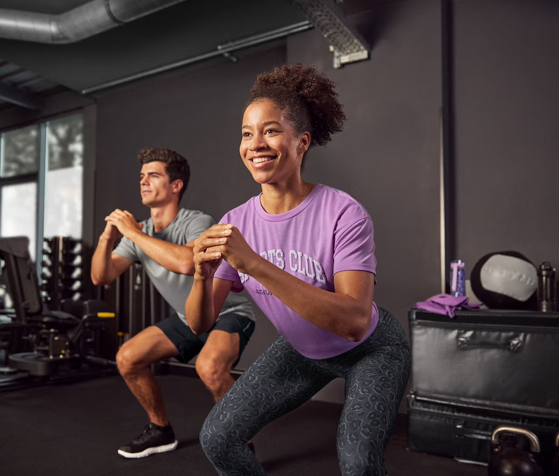 Junge Frau und junger Mann im Gym, beide in Sportoutfits